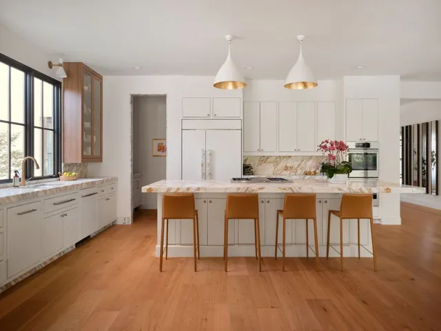a kitchen with cabinets a sink and chairs