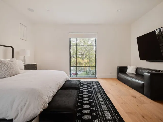 a bedroom with bed tv and window