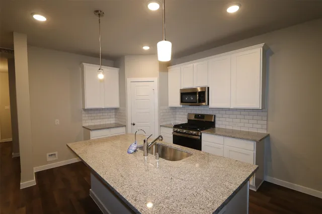 a kitchen with microwave a stove and a wooden floor