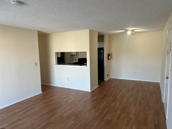 a view of a room with wooden floor and white walls