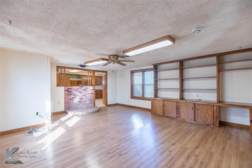 405 South Hinton Street Benjamin, TX 79505 - Photo 12 of 40 Unfurnished living room with a textured ceiling, light wood-type flooring, and a ceiling fan