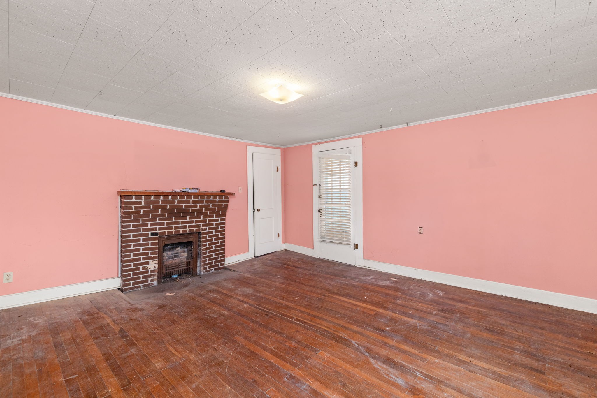 11051 Highway 64 Lexington, AL 35648 - Photo 12 of 44 a view of an empty room with wooden floor and a fireplace