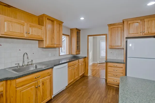 a kitchen with stainless steel appliances granite countertop a refrigerator a stove and a sink with cabinets