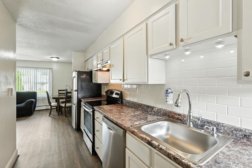 66 Applewood Drive, Unit 66 Chicopee, MA 01022 - Photo 13 of 25 a kitchen with kitchen island granite countertop a sink a counter top space appliances and cabinets