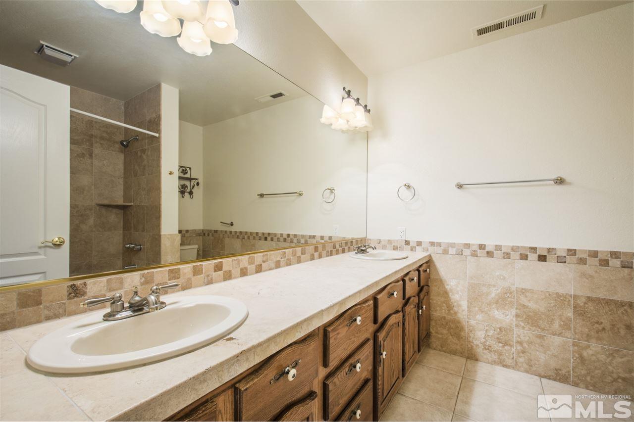 12560 Thomas Creek Road Reno, NV 89511 - Photo 15 of 20 a bathroom with a double vanity sink a mirror and a shower