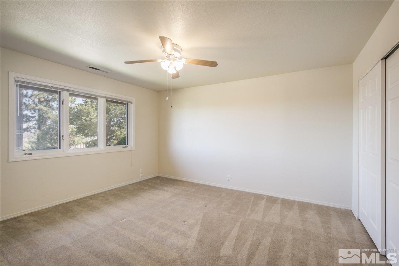 12560 Thomas Creek Road Reno, NV 89511 - Photo 16 of 20 an empty room with windows and chandelier fan