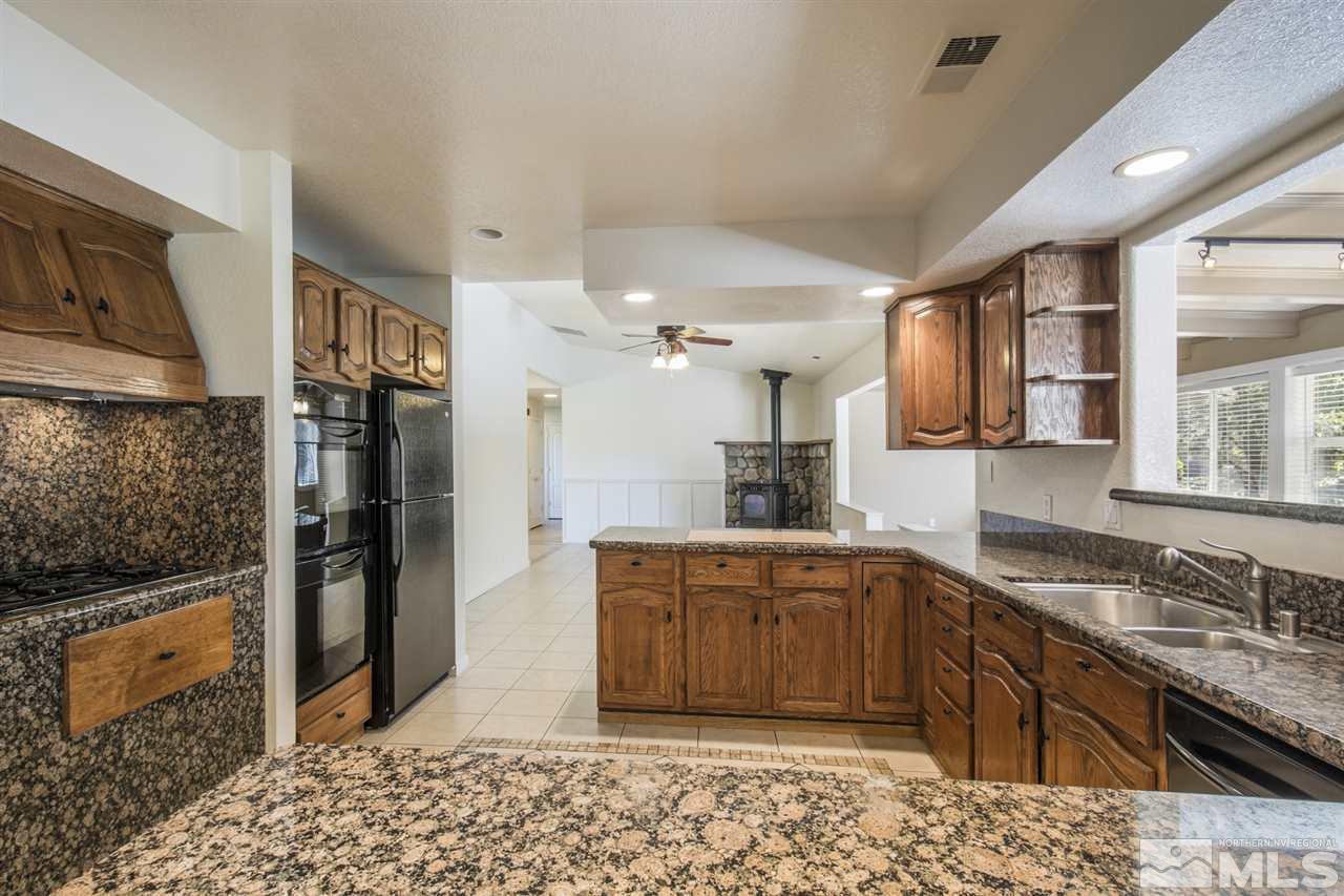 12560 Thomas Creek Road Reno, NV 89511 - Photo 8 of 20 a kitchen with stainless steel appliances granite countertop a sink stove and refrigerator