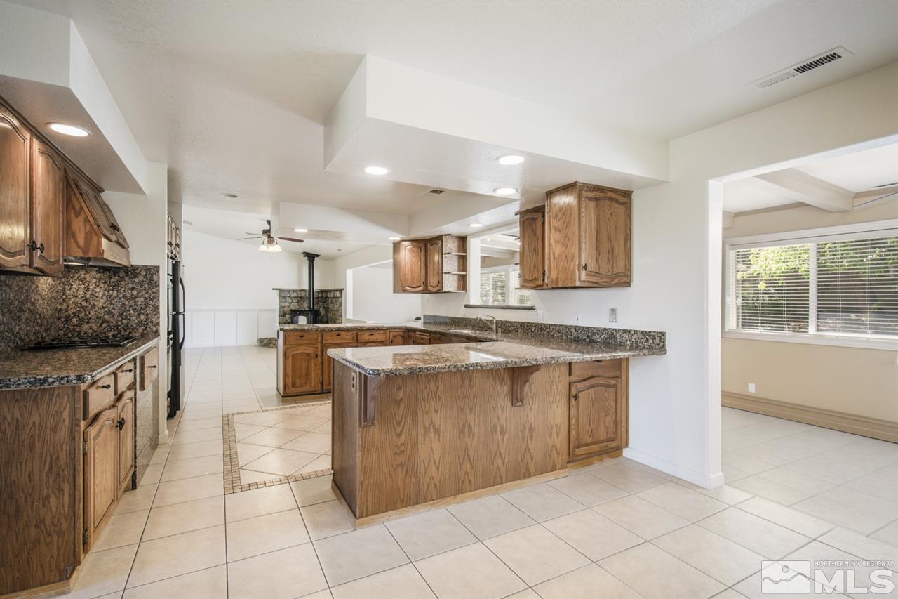12560 Thomas Creek Road Reno, NV 89511 - Photo 9 of 20 a kitchen with stainless steel appliances granite countertop a stove and a sink