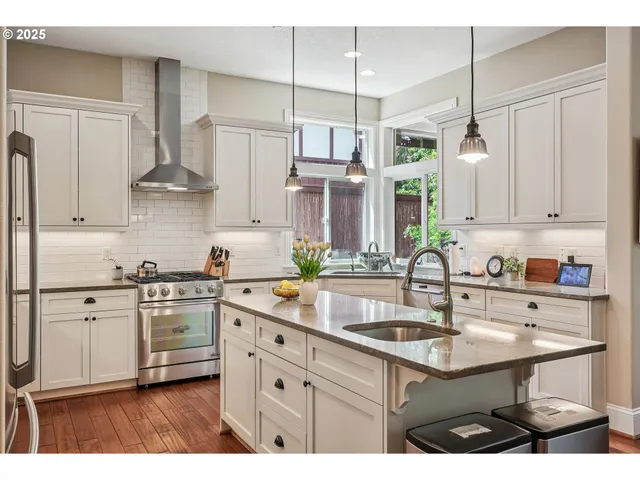 a kitchen with kitchen island granite countertop a sink stainless steel appliances and cabinets