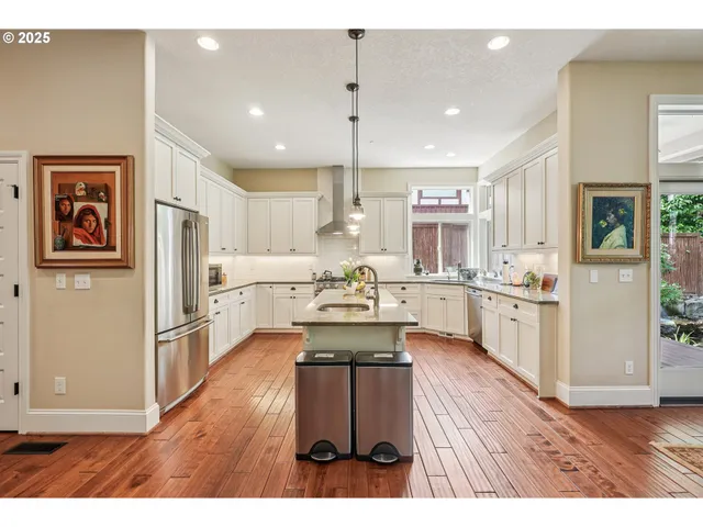 a open kitchen with cabinets wooden floor and stainless steel appliances