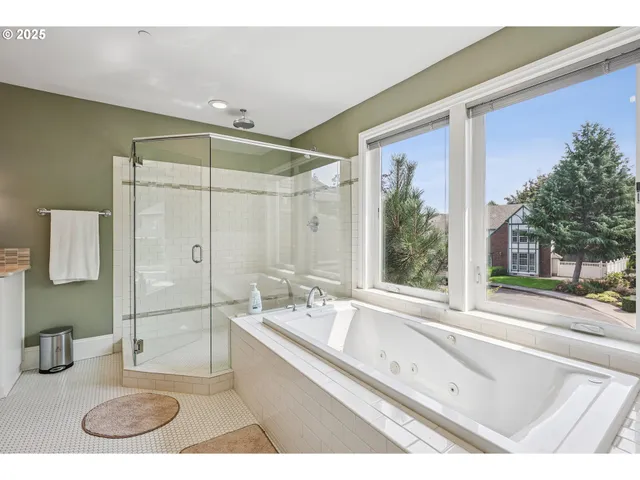 a bathroom with a tub a sink and a large mirror