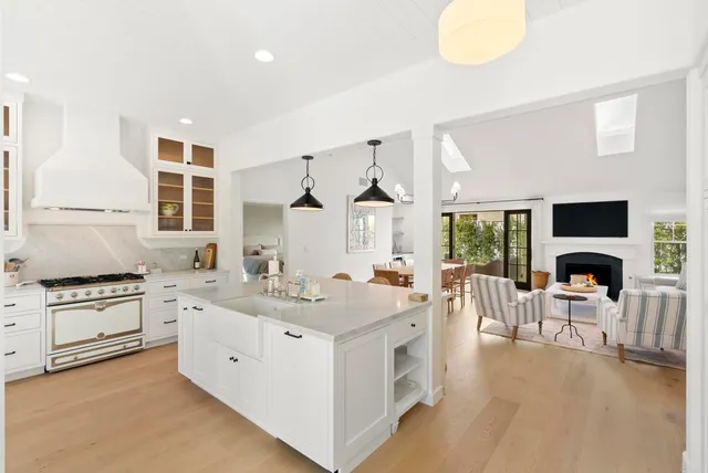 a view of living room kitchen with stainless steel appliances granite countertop furniture and a fireplace