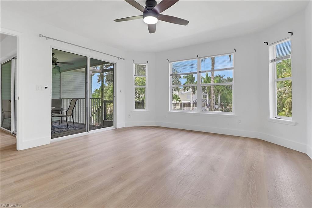 3659 Riviera Circle Bonita Springs, FL 34134 - Photo 11 of 31 a view of an empty room with a window and wooden floor