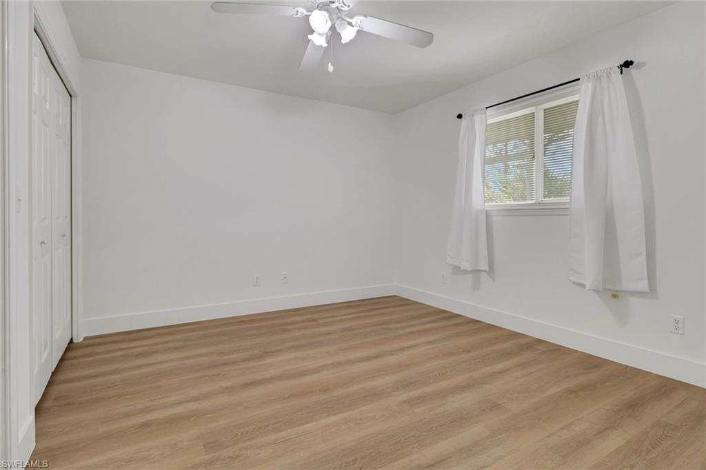 3659 Riviera Circle Bonita Springs, FL 34134 - Photo 14 of 31 a view of an empty room with wooden floor and a window