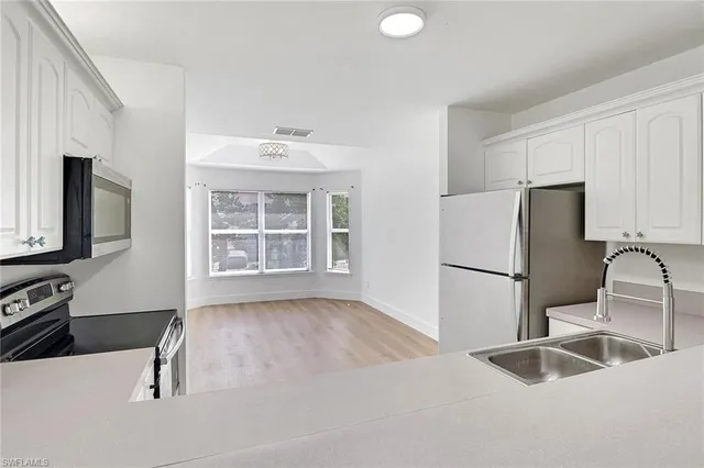 a kitchen with a refrigerator sink and cabinets