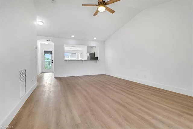 a view of empty room with wooden floor and window