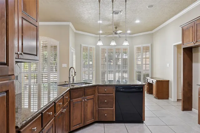 a large kitchen with granite countertop a sink and cabinets