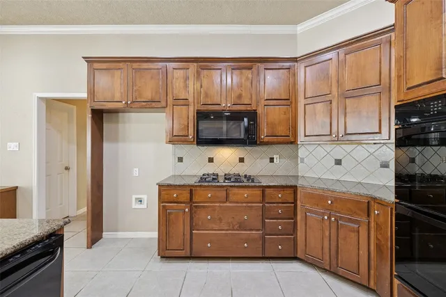 a kitchen with stainless steel appliances granite countertop a refrigerator and a stove top oven