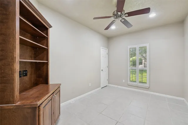 a view of an empty room with a cabinets and a window