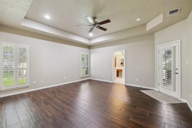 a view of an empty room with a window and wooden floor