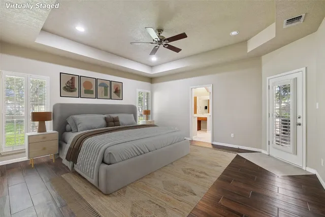 a spacious bedroom with a large bed and a chandelier