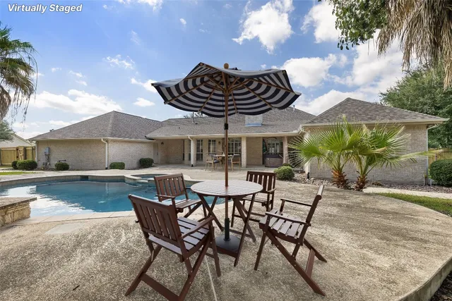 a patio with a table and chairs and potted plants