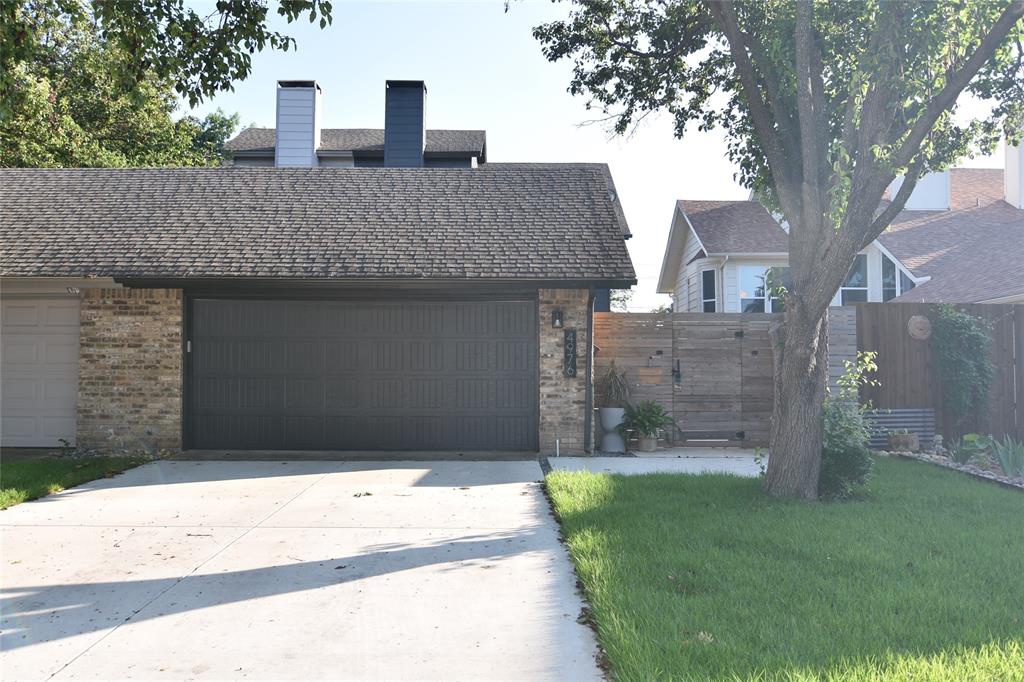 a front view of a house with a garden and trees