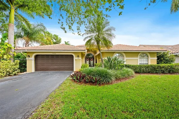 a front view of a house with a garden and yard