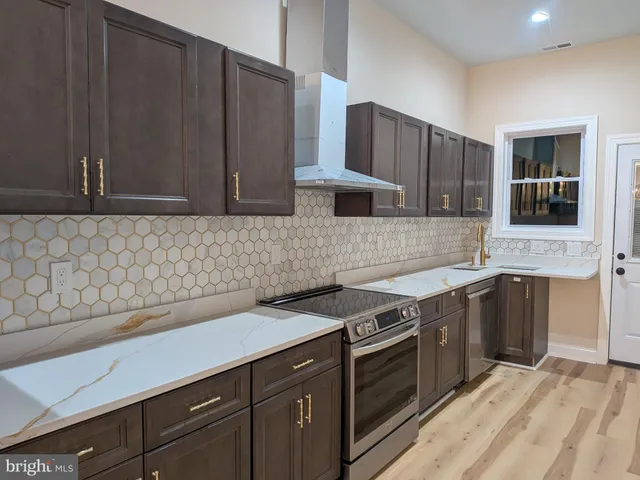 a kitchen with stainless steel appliances granite countertop a sink stove and cabinets