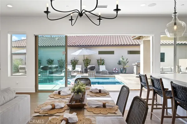 a dining room with furniture a chandelier and wooden floor