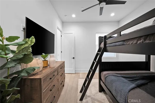 a bedroom with a bed and a flat tv screen on a dresser