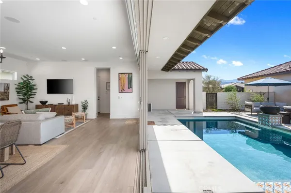 a living room with furniture a flat screen tv and kitchen view