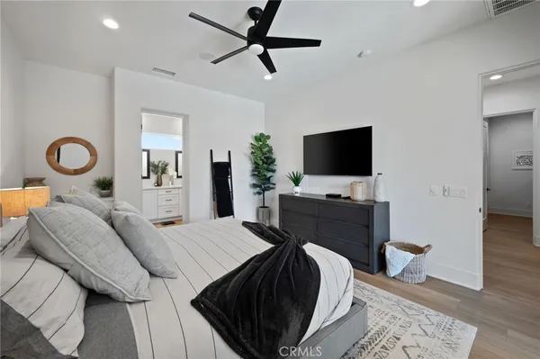 a bedroom with a bed flat screen tv and a potted plant