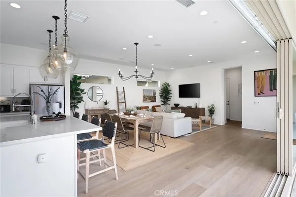 a view of a dining room and livingroom with furniture wooden floor a chandelier