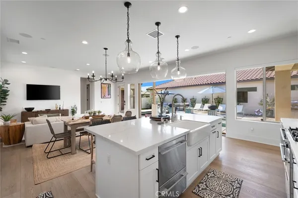 a large white kitchen with a large island in the center