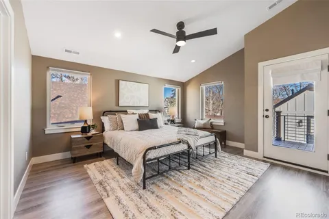 a spacious bedroom with a bed a window and dresser