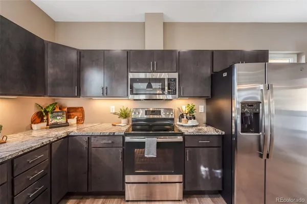 a kitchen with stainless steel appliances granite countertop a stove a refrigerator and a sink