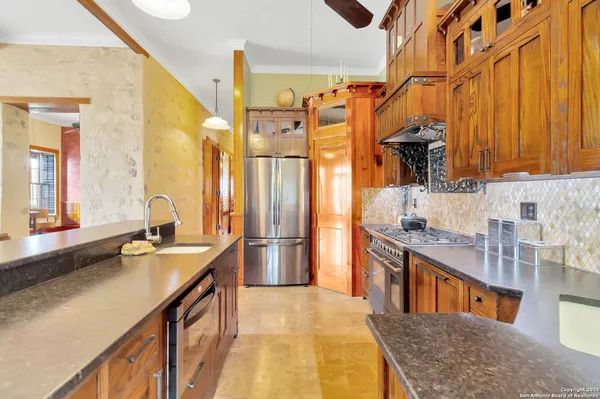 a kitchen with stainless steel appliances granite countertop a sink stove and refrigerator