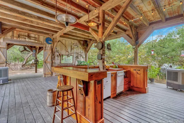 a view of a chairs and table on the wooden roof deck