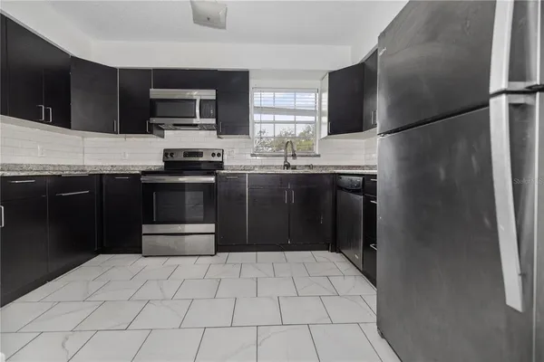 a kitchen with stainless steel appliances a refrigerator sink microwave and cabinets