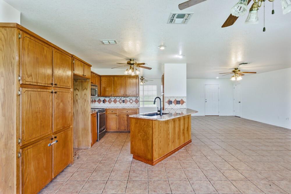 4316 Leona Road Bowie, TX 76230 - Photo 5 of 37 a kitchen with stainless steel appliances a refrigerator sink and cabinets