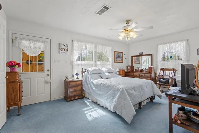 a spacious bedroom with a bed and a chandelier