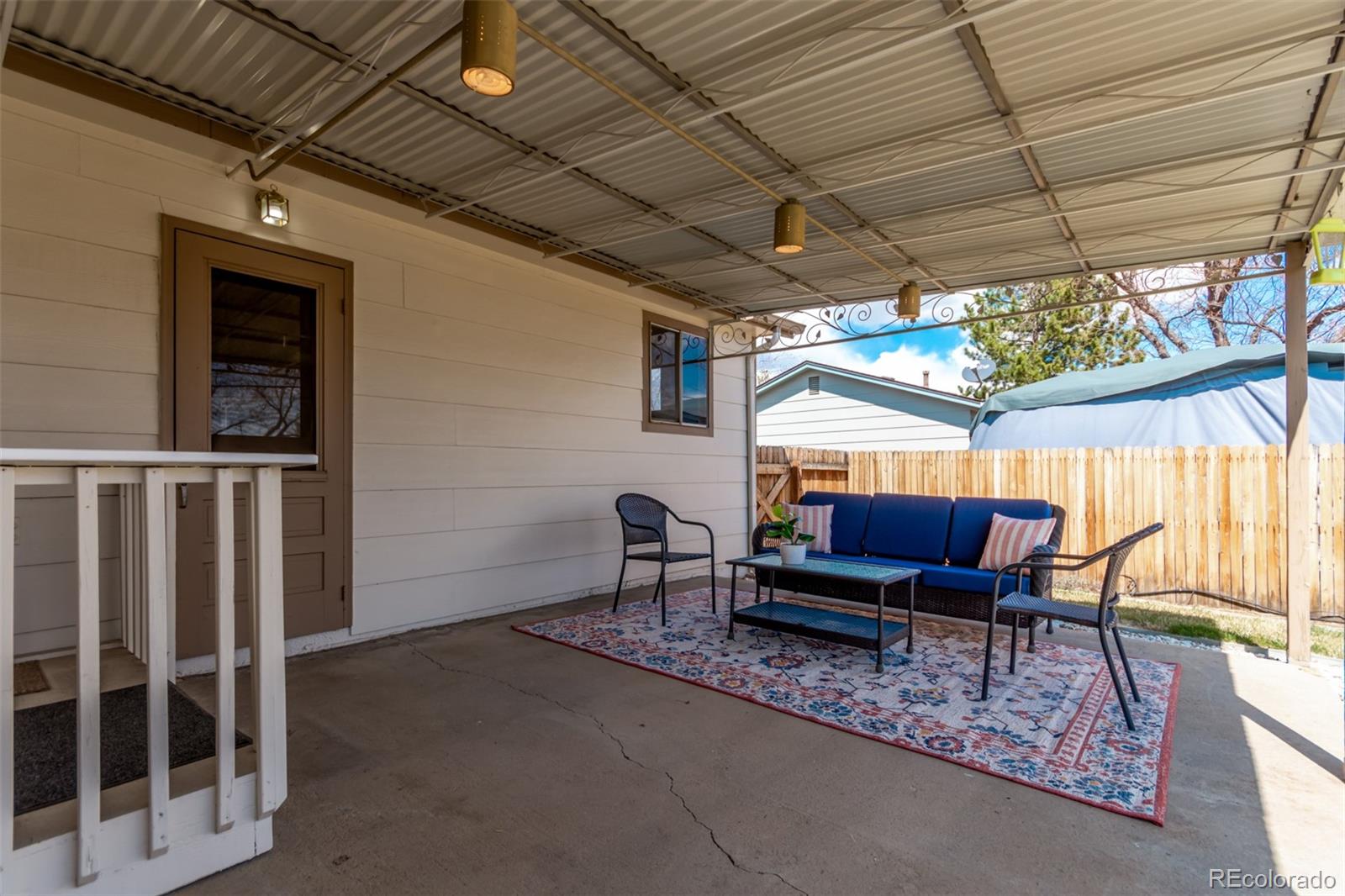 7720 Kendall Street Arvada, CO 80003 - Photo 30 of 45 a outdoor living space with furniture and a black umbrella