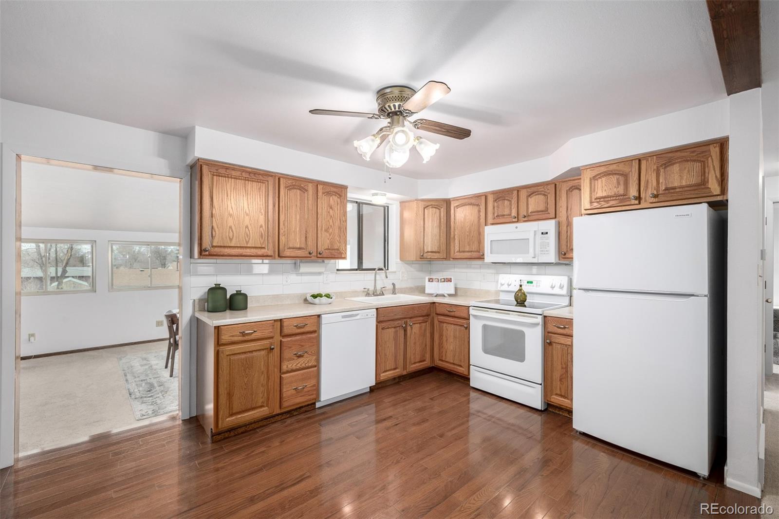 7720 Kendall Street Arvada, CO 80003 - Photo 8 of 45 a kitchen with white cabinets and white appliances