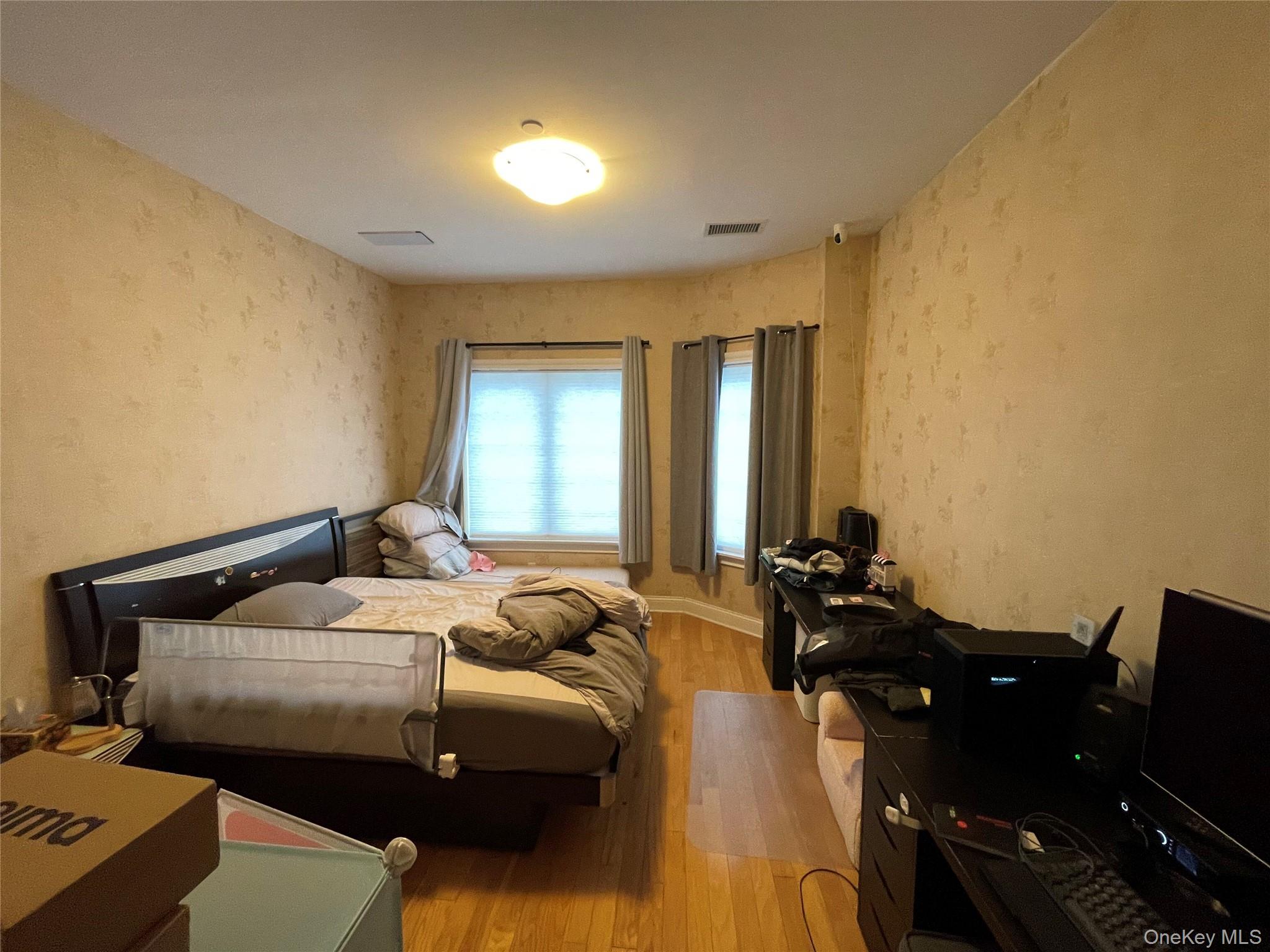 350 Soundview Lane Queens, NY 11356 - Photo 5 of 11 a bedroom with a bed and wooden floor