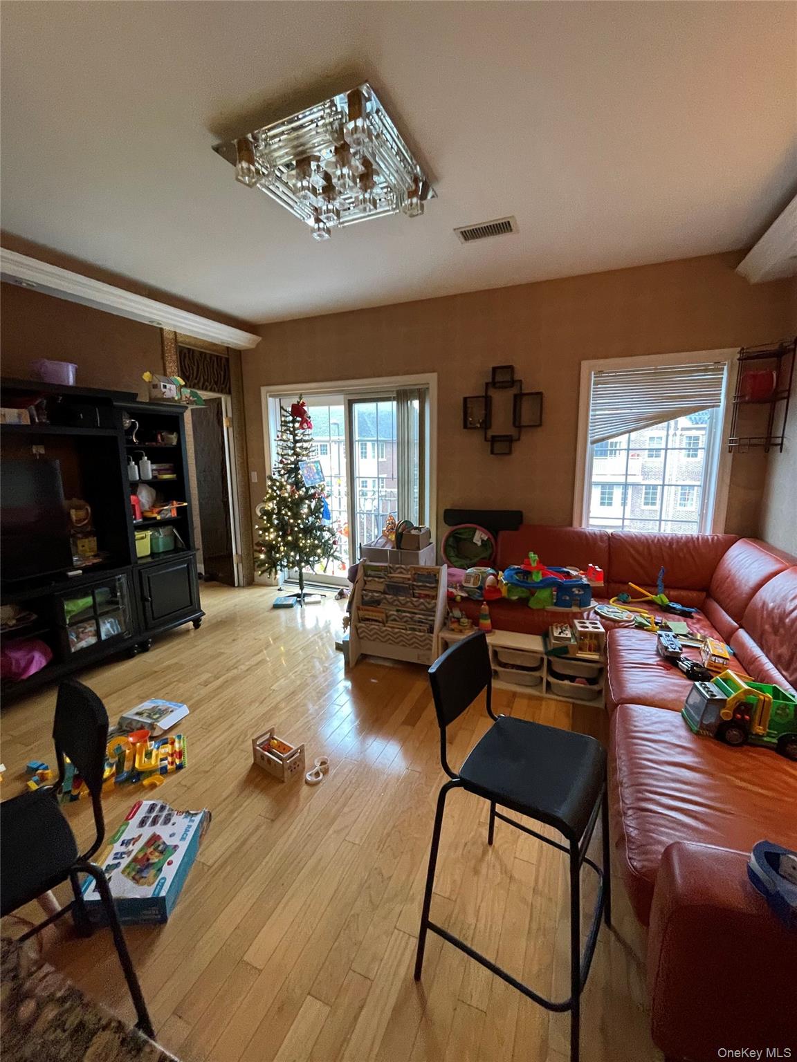 350 Soundview Lane Queens, NY 11356 - Photo 9 of 11 a living room with furniture or couch and a chandelier