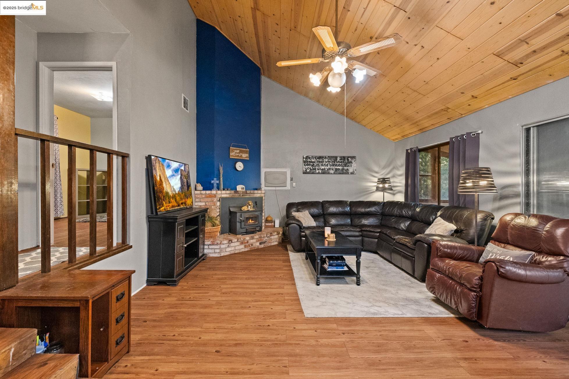 a living room with furniture a lamp wooden floor and a chandelier