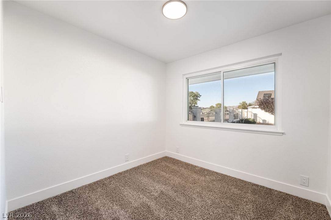 429 Crestway Road Henderson, NV 89015 - Photo 32 of 56 A well-lit bedroom features plush carpeting and a large window offering a scenic outdoor perspective.