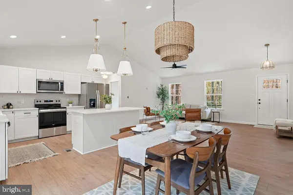 a kitchen with a dining table chairs sink and stove