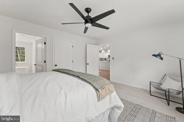 a spacious bedroom with a bed and ceiling fan